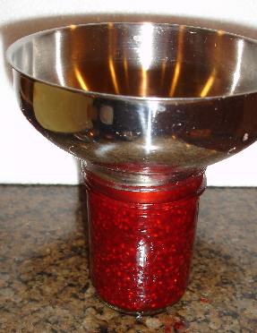 Filling the canning jar with a stainless steel funnel